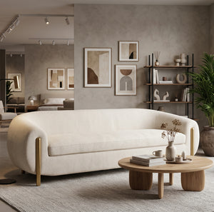 Cream sofa with brass legs styled in showroom